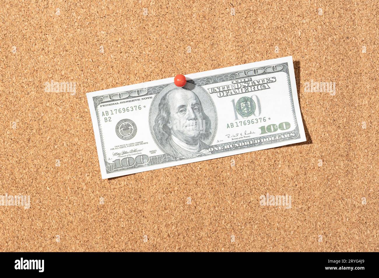 Falsa banconota da cento dollari fissata sul bordo del sughero Foto Stock
