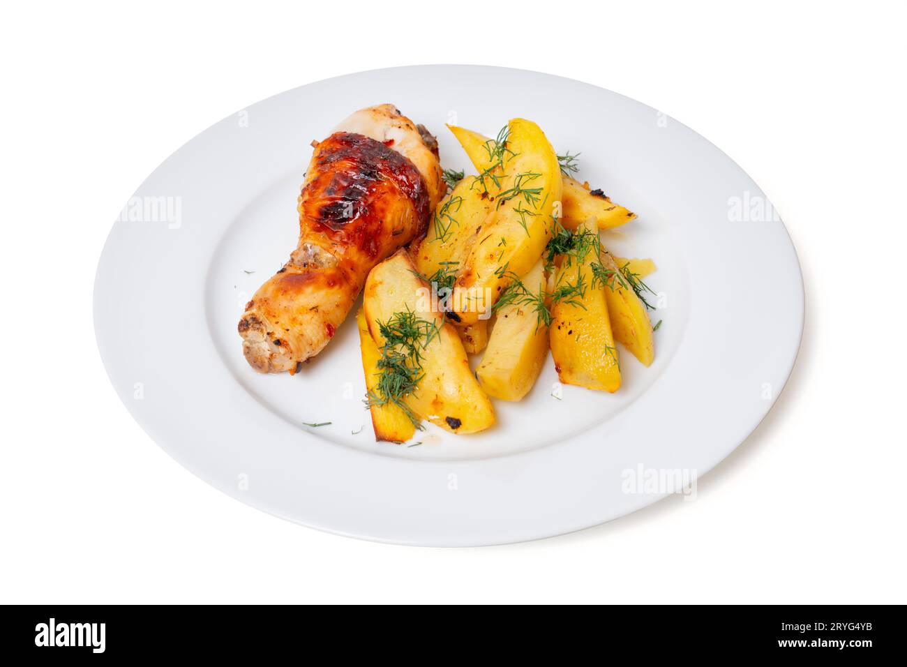 Delizioso piatto di patate al forno e cosce di pollo, abbondantemente cosparso di aneto fresco, per un pasto appetitoso. Foto Stock
