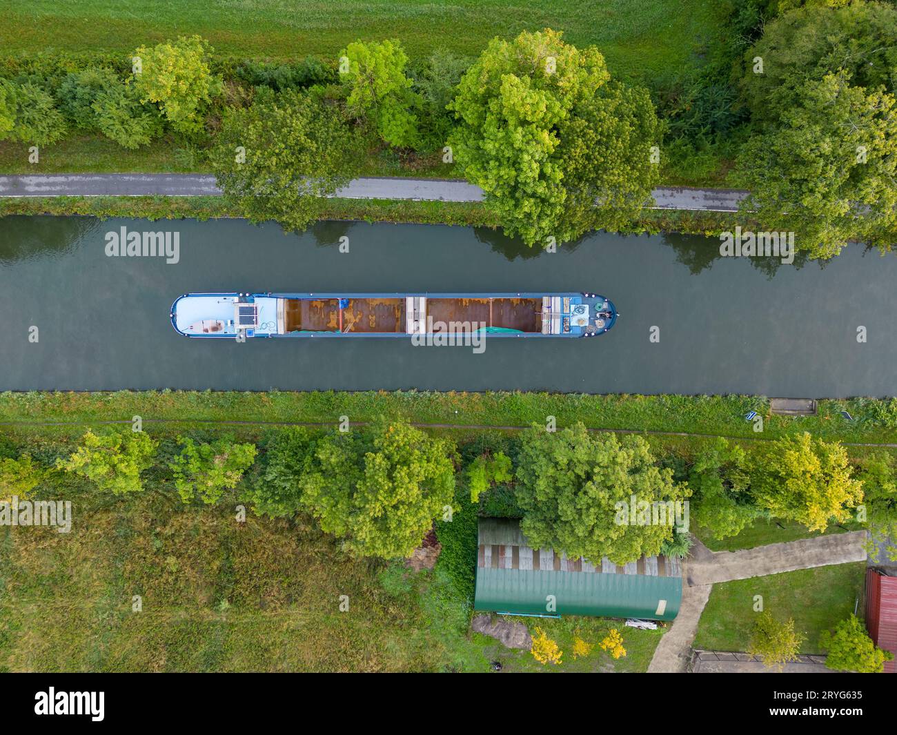 Vista aerea di un canale con una nave cargo in Belgio. Canali con acqua per i trasporti, l'agricoltura. Campi e prati. Orizzontale Foto Stock