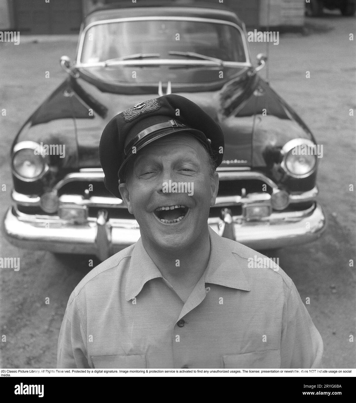 Negli anni '1950 Un uomo vicino alla sua auto e si vede essere felice e sorridente. Forse non così strano come è il proprietario di un'impressionante auto americana del marchio Chrysler Imperial. Negli anni '1950, molti dettagli sono stati cromati: griglia, paraurti, modanature. Svezia 1951. Kristoffersson rif. BP30-8 Foto Stock
