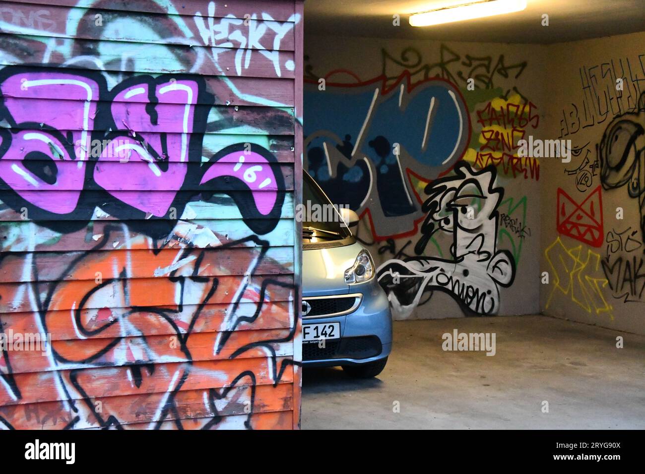 Smart ForTwo in piedi in un carport coperto di graffiti Foto Stock