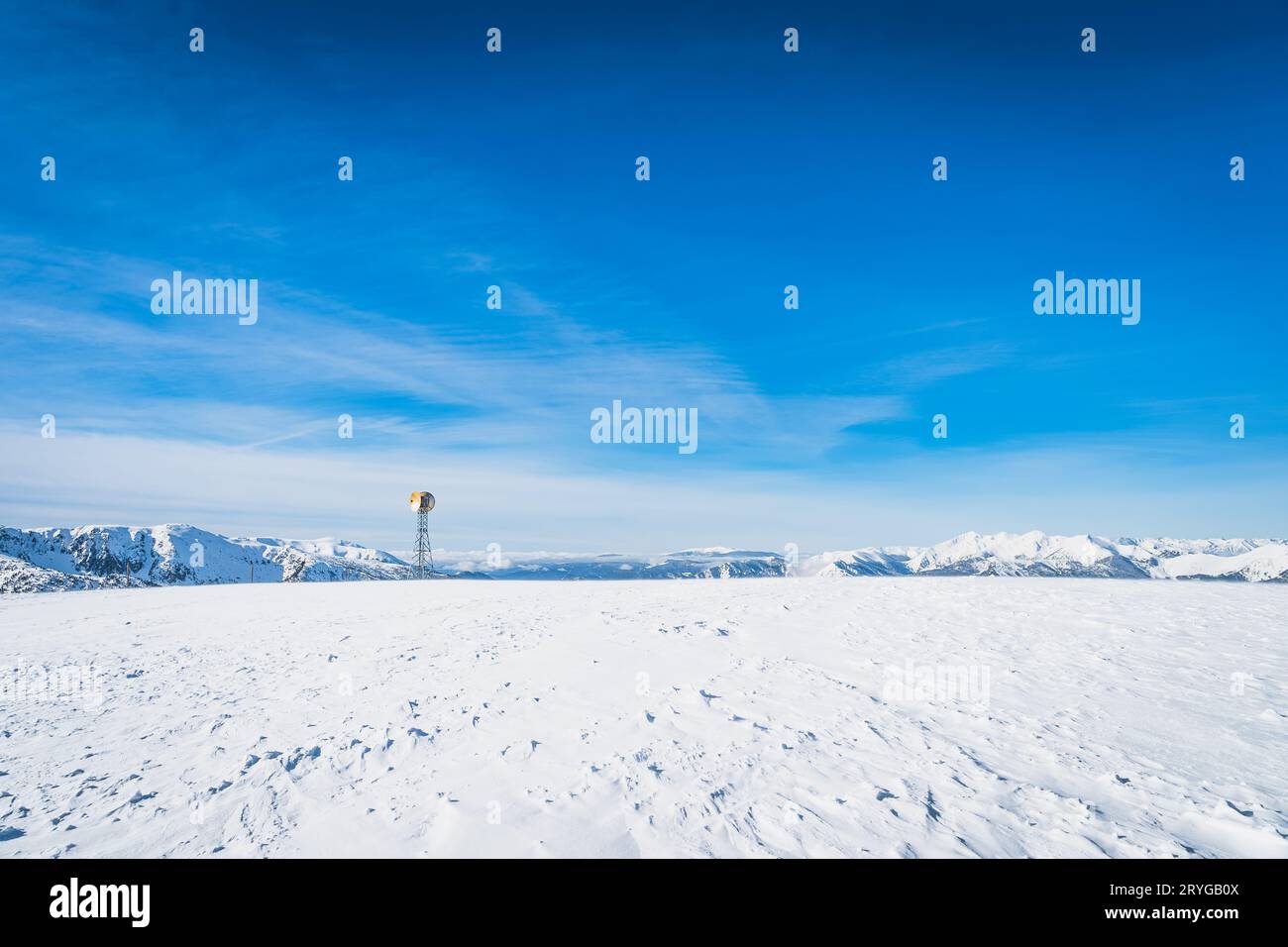 Una torre radio con due piatti satellitari sulla cima di una montagna innevata, Andorra Foto Stock