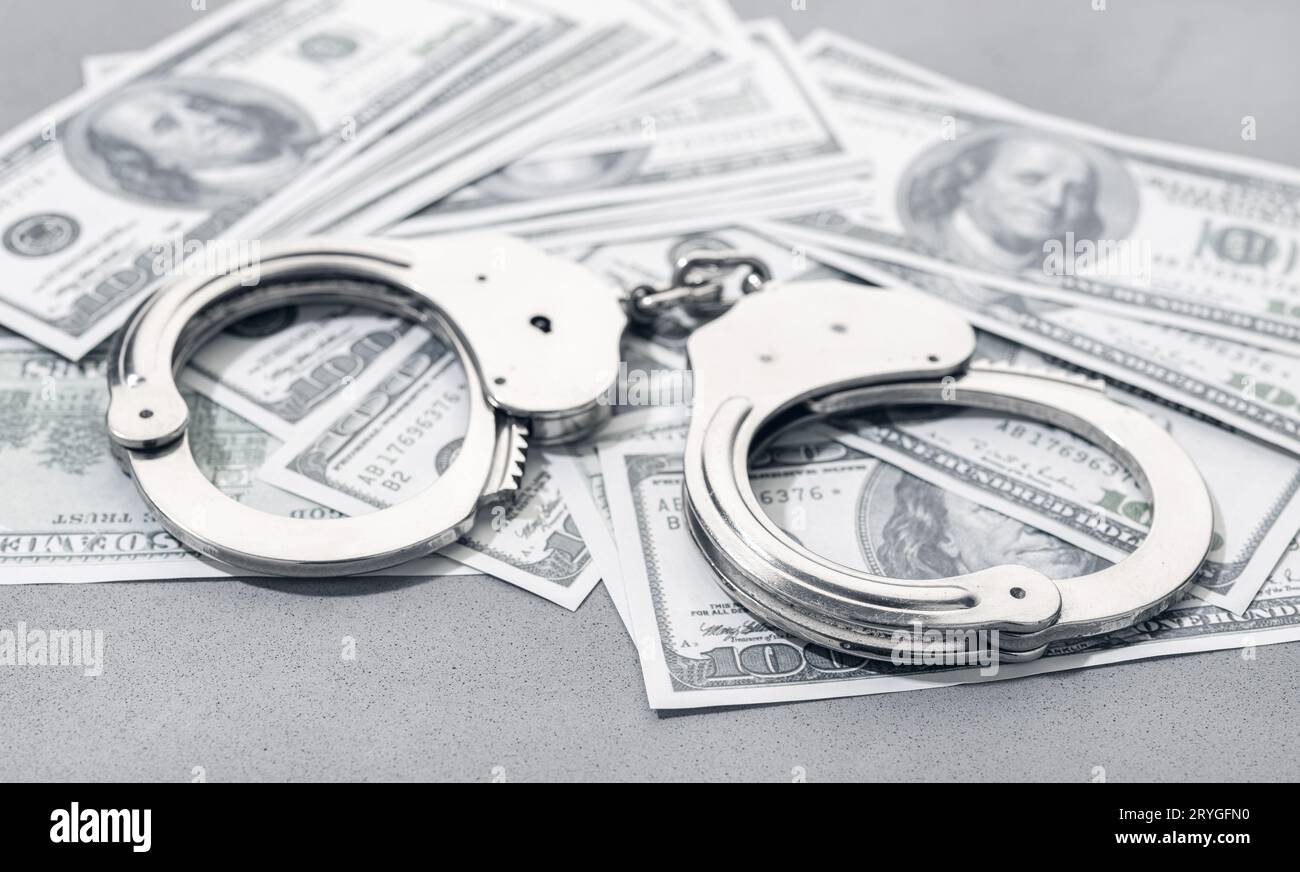 Manette sulle banconote in dollari USA sfondo denaro. Concetto di corruzione o criminalità finanziaria Foto Stock