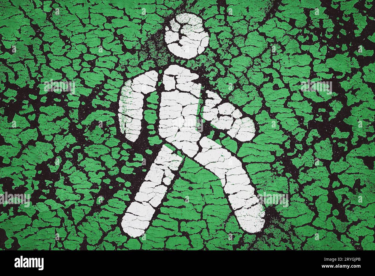 Icona pedonale verde. Vernice incrinata sull'asfalto. Concetto di priorità per l'ambiente e i pedoni Foto Stock
