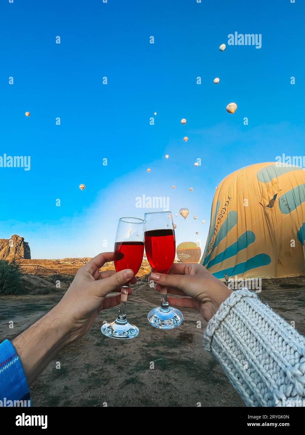 Mongolfiera che vola su paesaggi rocciosi in Cappadocia con un bel cielo sullo sfondo Foto Stock
