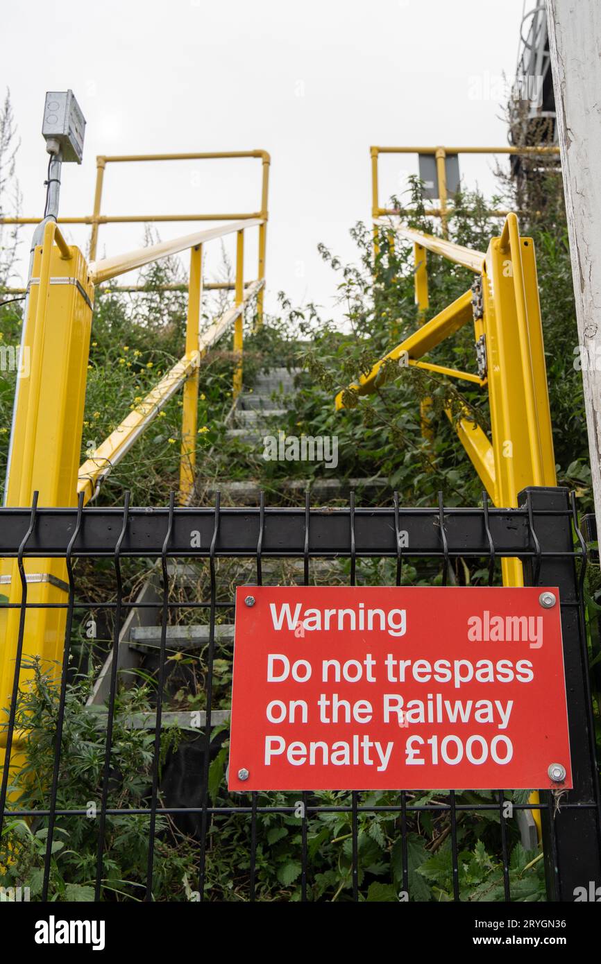 Segnale del Regno Unito che avverte contro le violazioni della linea ferroviaria. Foto Stock
