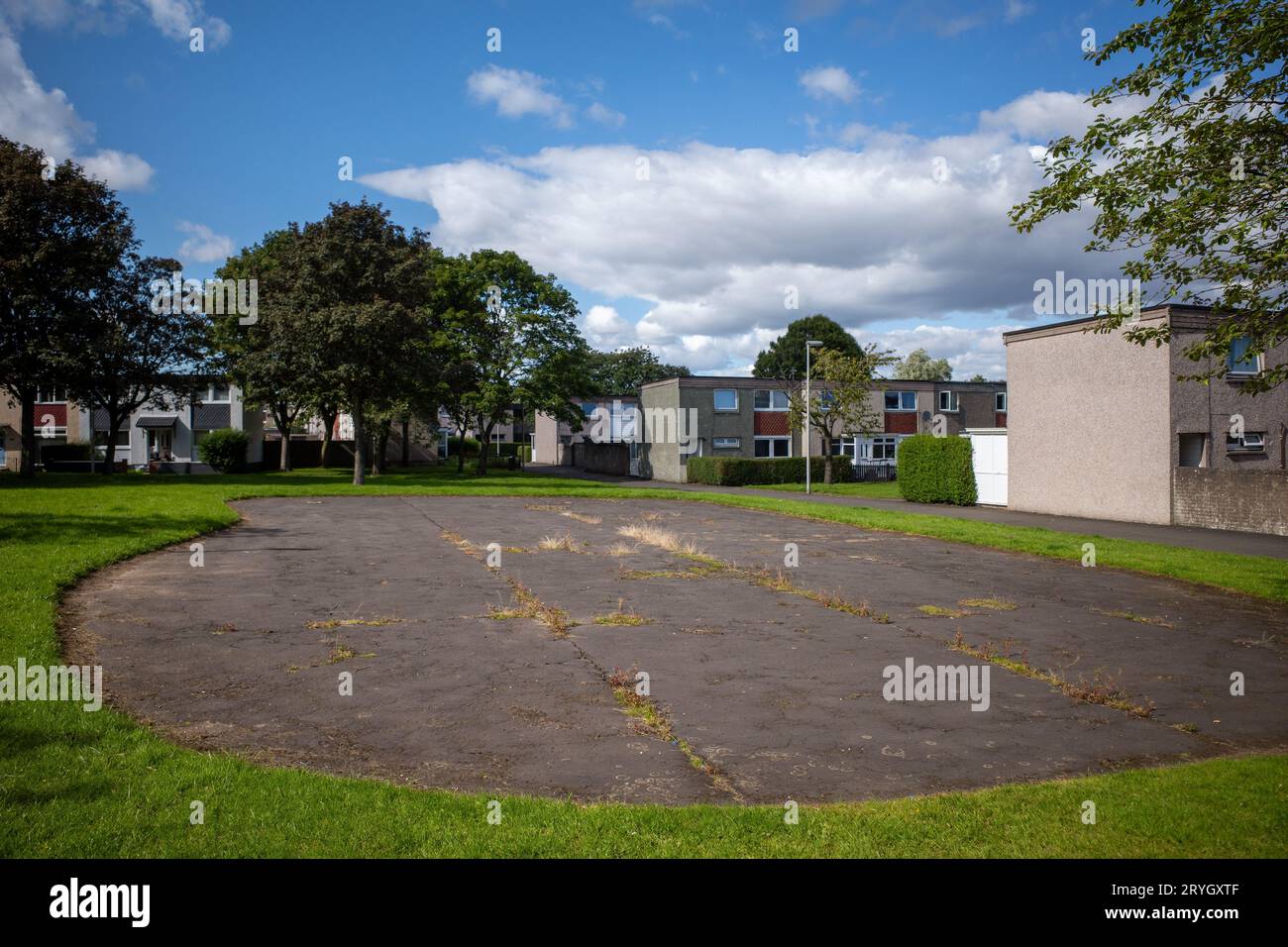Un'area di cemento abbandonata è vuota, un parco giochi per bambini era qui. Il cemento è un promemoria per gli adulti che giocavano qui, Glenrothes. Foto Stock