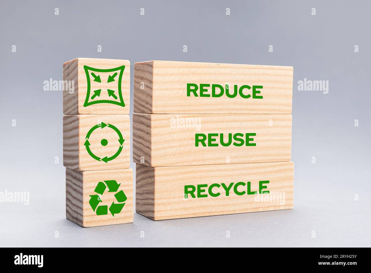 Riduci le icone di riciclo e le parole su blocchi di legno su sfondo grigio Foto Stock