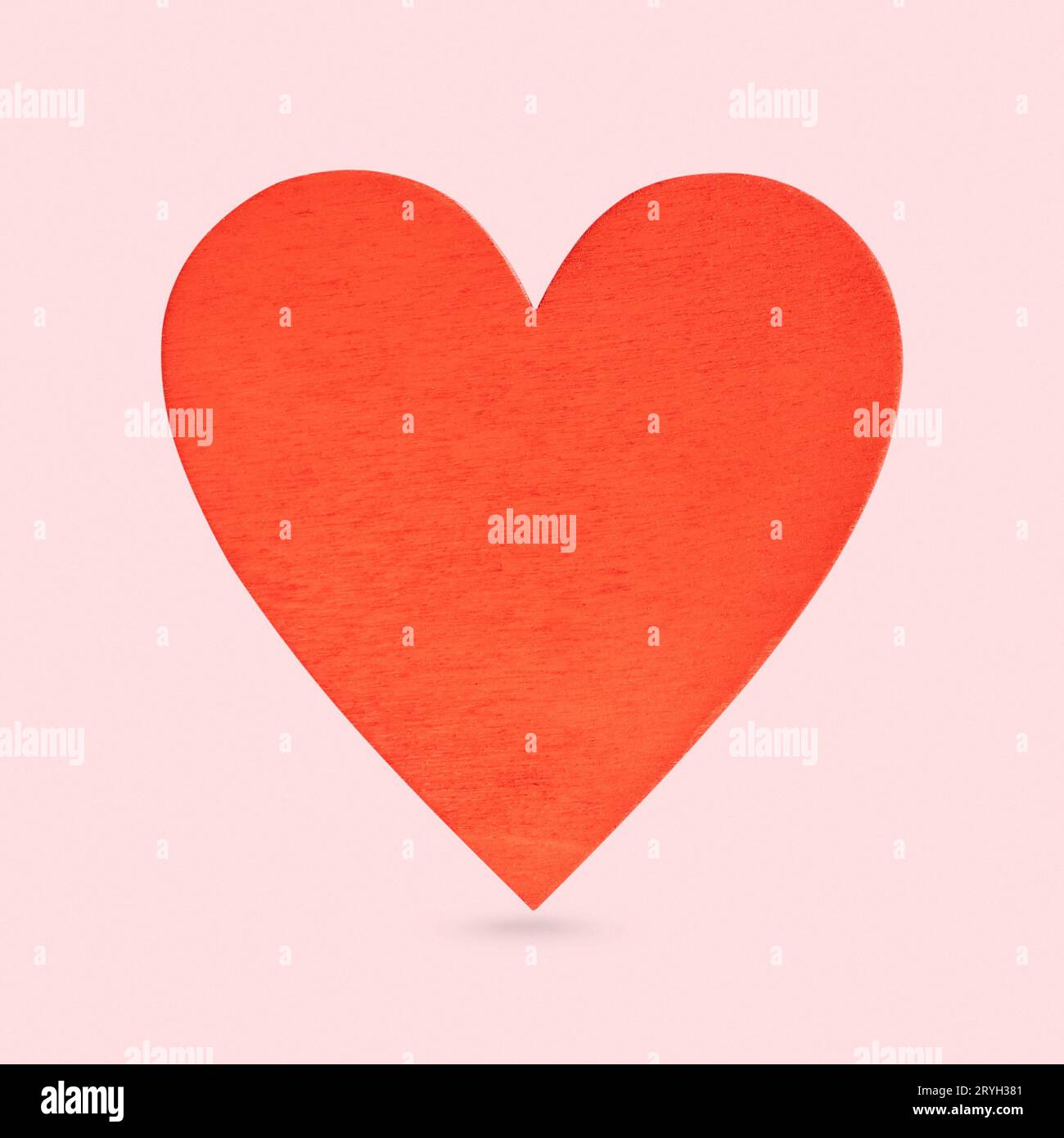 Forma di cuore rosso in legno isolato su sfondo rosa Foto Stock