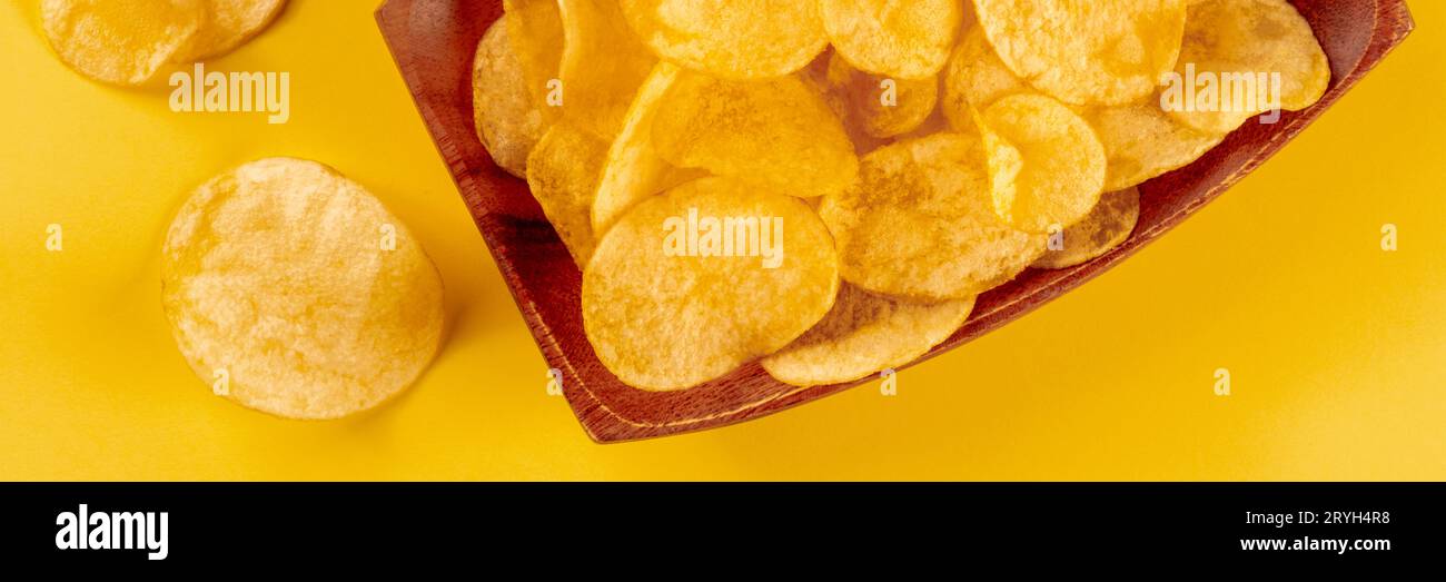 Patatine fritte o patatine, uno spuntino salato su sfondo giallo Foto Stock
