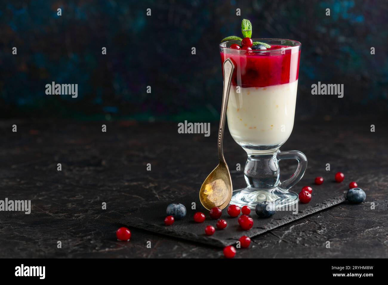 Latte e gelatina di frutti di bosco (budino) in un bicchiere. Foto Stock