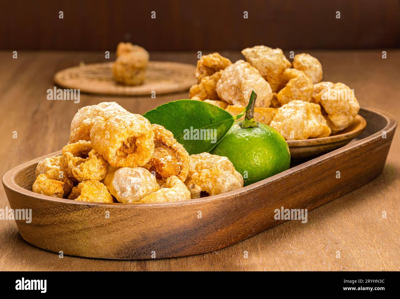 Pila di croccanti di maiale fritti e croccanti fatti in casa in vassoio di legno Foto Stock