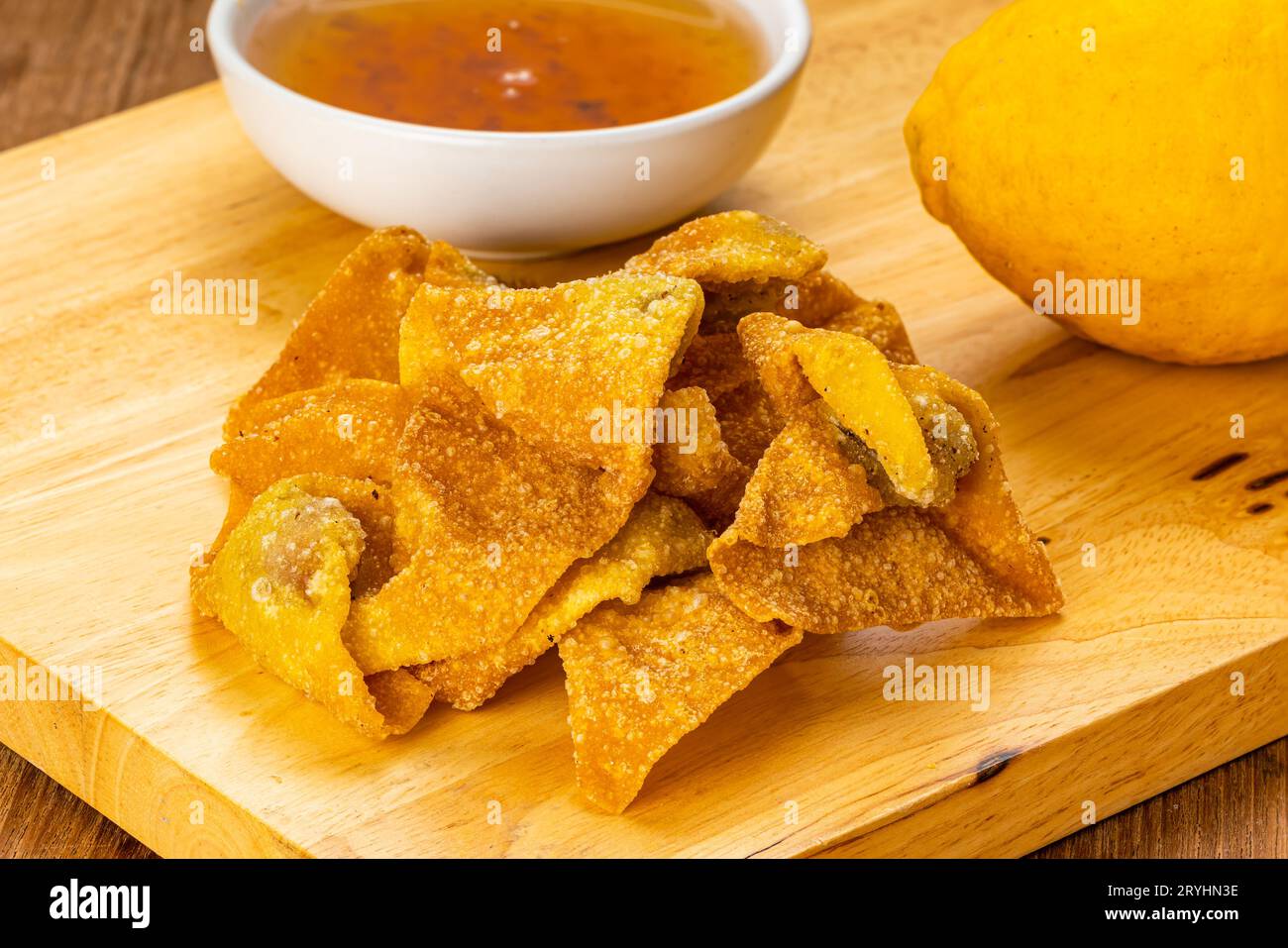 Vista ad alto angolo di un mucchio di deliziosi wonton fritti in casa su un tagliere di legno. Foto Stock