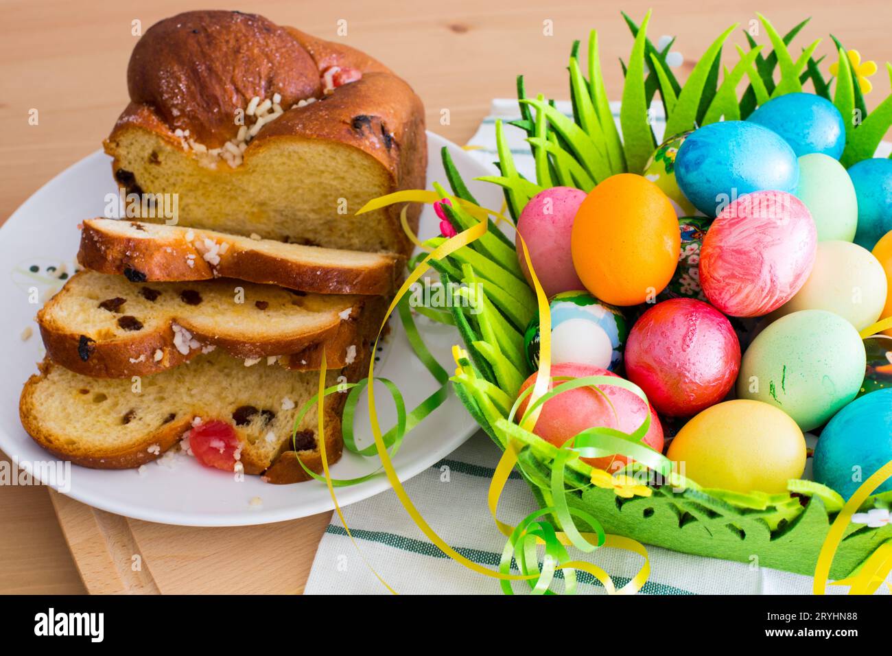 Bellissimi fiori gialli primaverili, uova di Pasqua e tradizionale torta natalizia Foto Stock