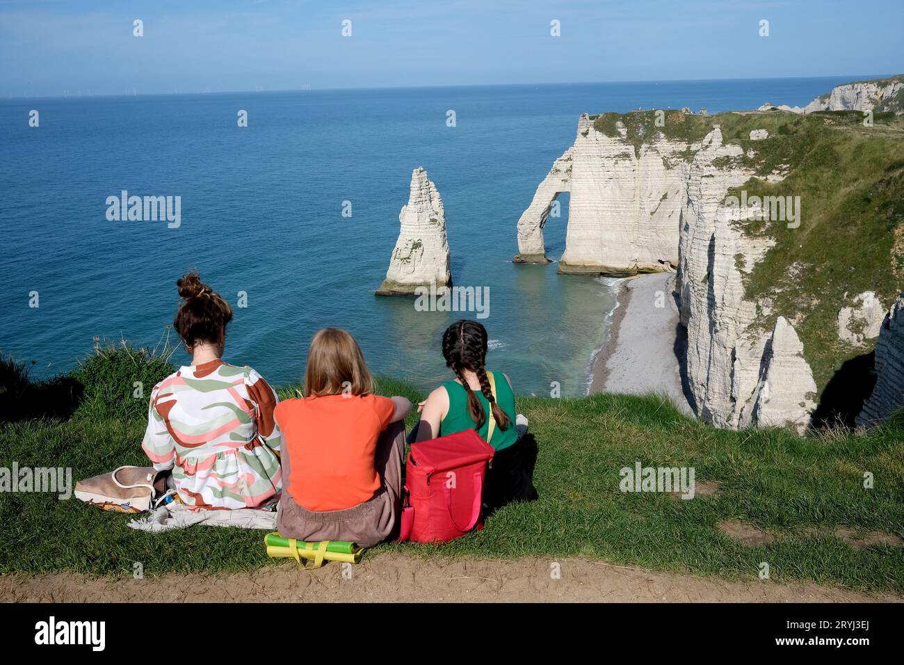 I turisti si godono la vista della spiaggia di Etretat con le sue famose scogliere di gesso e le formazioni rocciose costiere. Francia, Francia, Normandia, 2023 Falaises Foto Stock