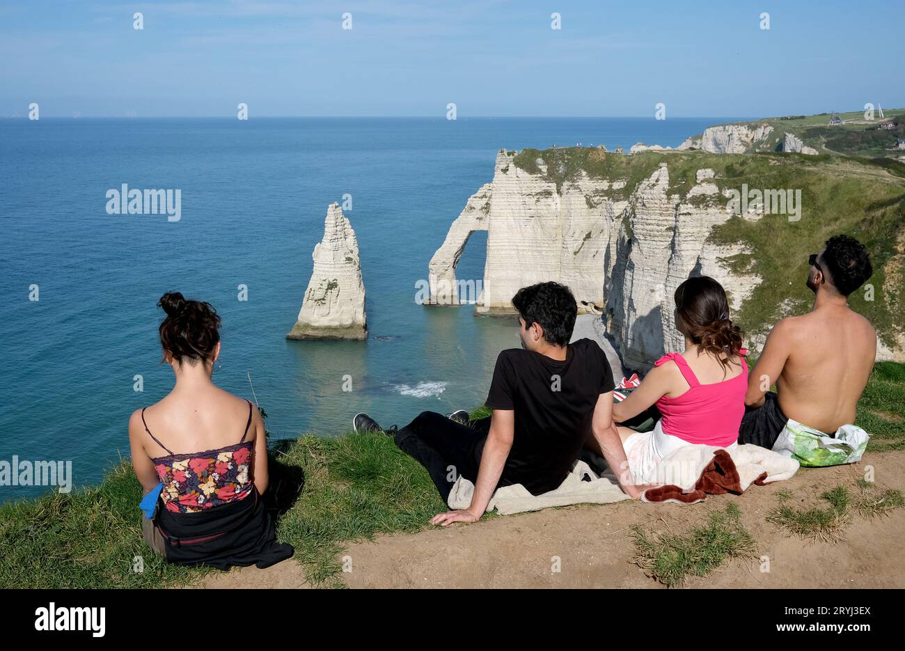 I turisti si godono la vista della spiaggia di Etretat con le sue famose scogliere di gesso e le formazioni rocciose costiere. Francia, Francia, Normandia, 2023 Falaises Foto Stock