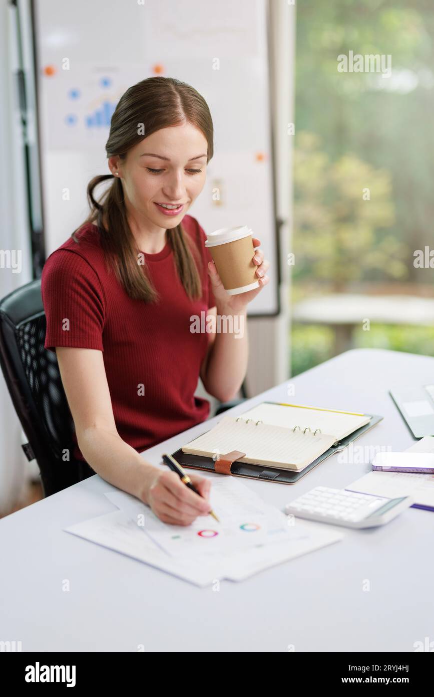 Concetto di business Office donna che lavora, Businesswoman sorriso mentre lavorando sul suo piano di invesment con l'analisi di documenti e di business investment gr Foto Stock