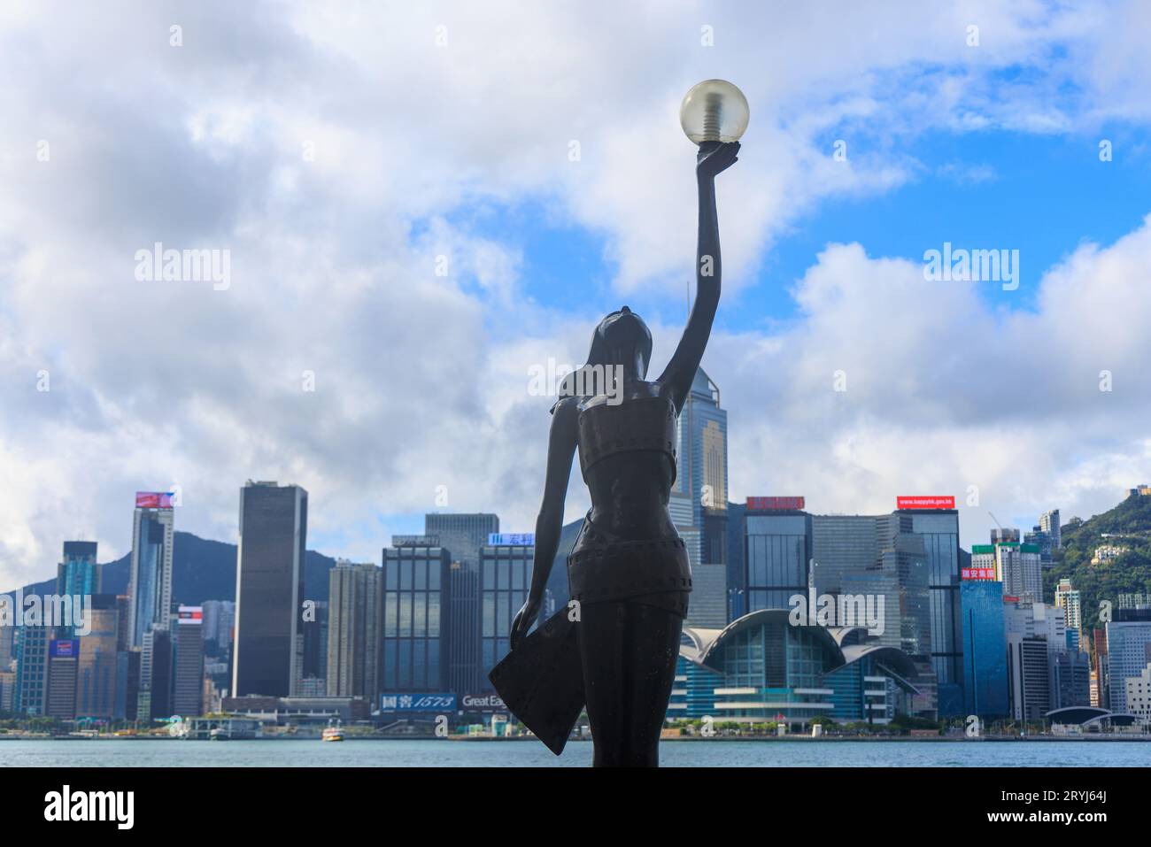 Hong Kong, 8 settembre 2023: Statua che regge alti e luminosi edifici sulla Avenue of the Stars Foto Stock