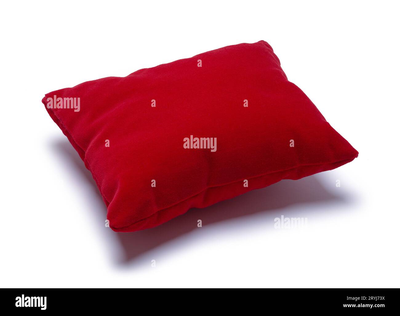 Cuscino in velluto rosso intagliato su bianco. Foto Stock