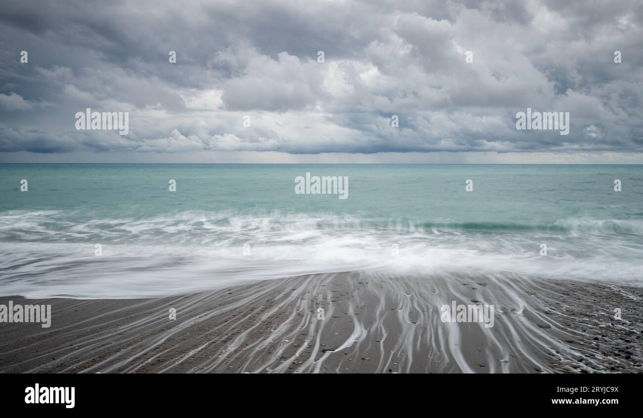 Onde ventose che si infrangono su una costa in una giornata di tempesta in inverno. Foto Stock