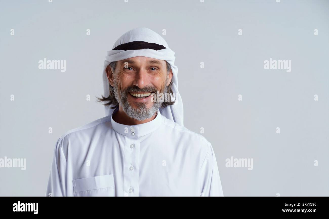 Uomo arabo sorridente e felice in disordine, abbigliamento tradizionale indossato da uomini musulmani in Medio Oriente, isolato su sfondo bianco Foto Stock
