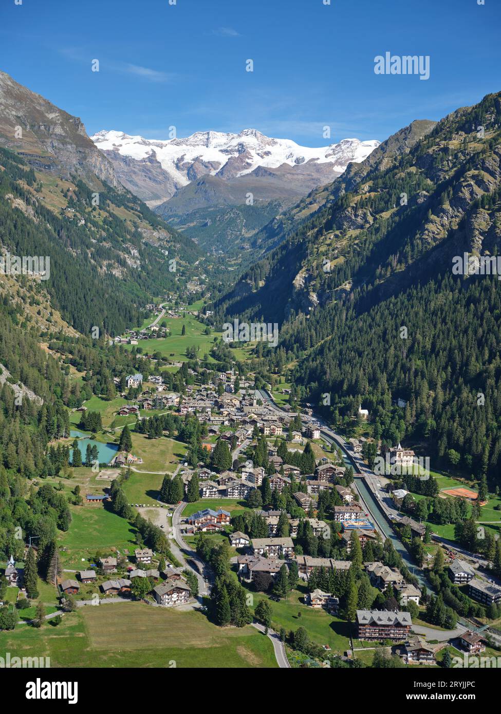 VISTA AEREA. Villaggio di Gressoney-Saint-Jean con il Monte Lyskamm (4533 metri) in lontananza. Valle d'Aosta, Italia. Foto Stock