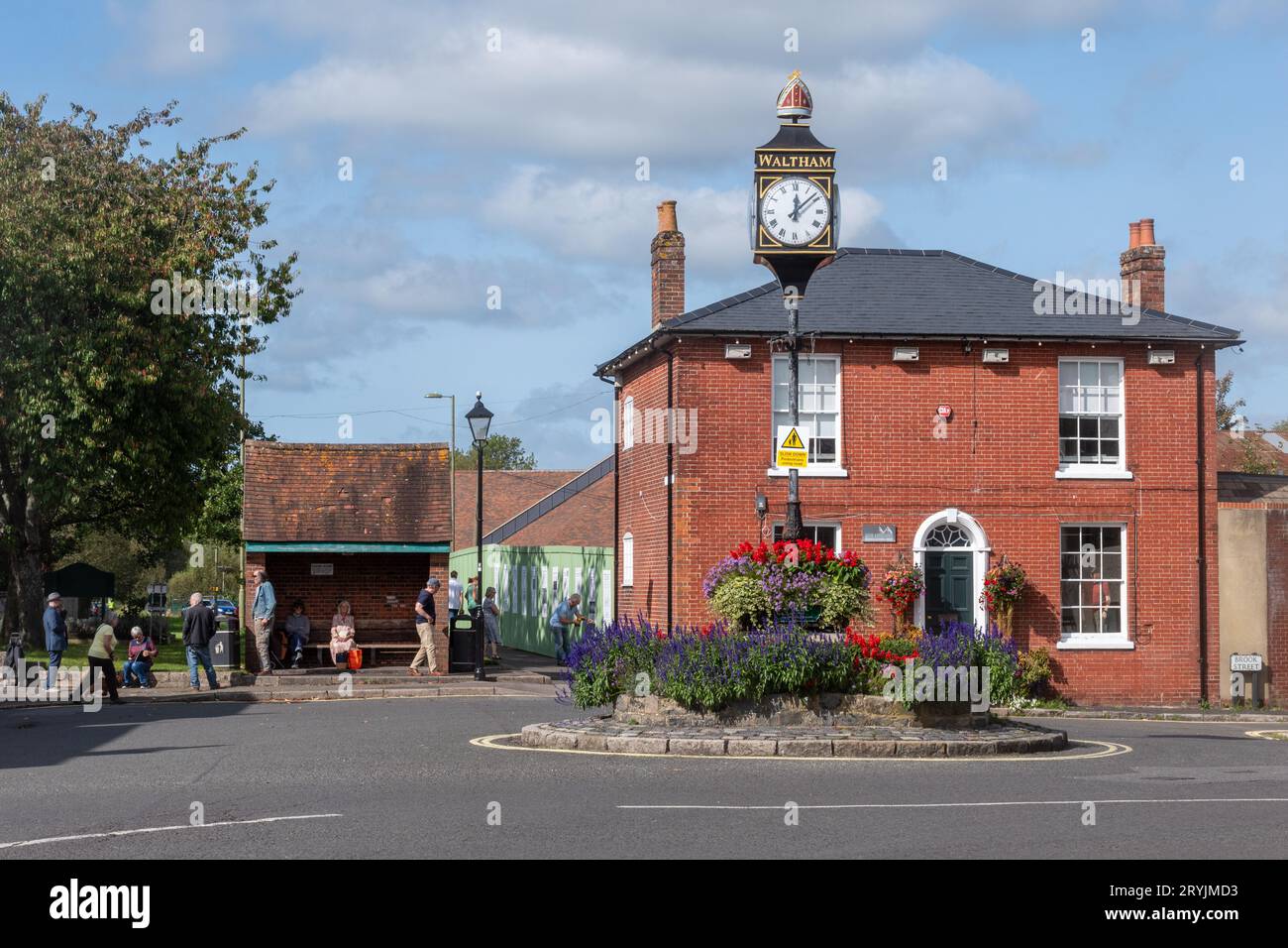 Bishop's Waltham, Hampshire, Inghilterra, Regno Unito, vista sulla strada di St George's Square e orologio nella storica città mercato, in una giornata di sole Foto Stock