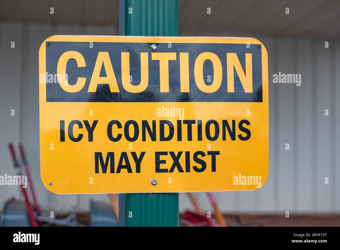 Cartello giallo e nero davanti a un'azienda avverte, attenzione, condizioni di ghiaccio possono esistere. Foto Stock