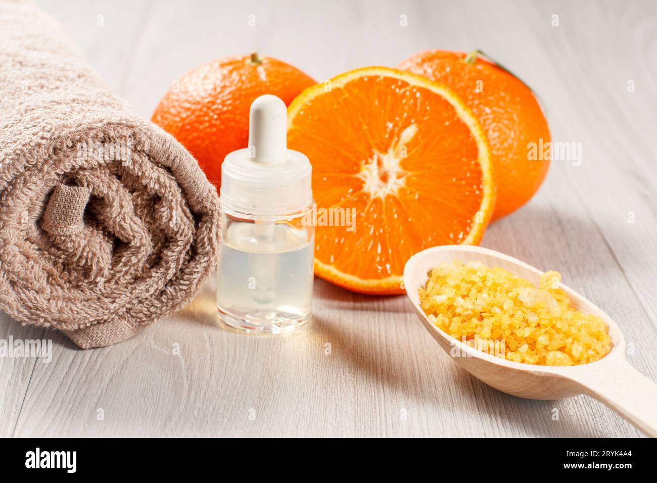 Tagliare l'arancia, l'asciugamano, la bottiglia con olio aromaterapico e il cucchiaio di legno con sale marino. Foto Stock