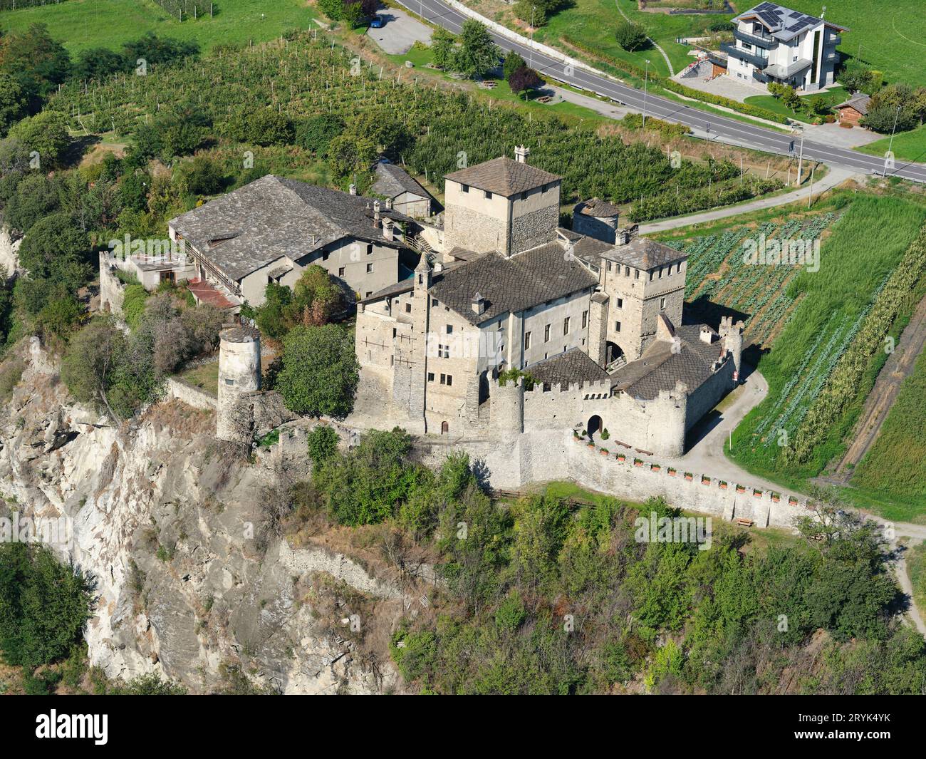 VISTA AEREA. Château Sarriod de la Tour in cima a una scogliera. Saint-Pierre, Valle d'Aosta, Italia. Foto Stock