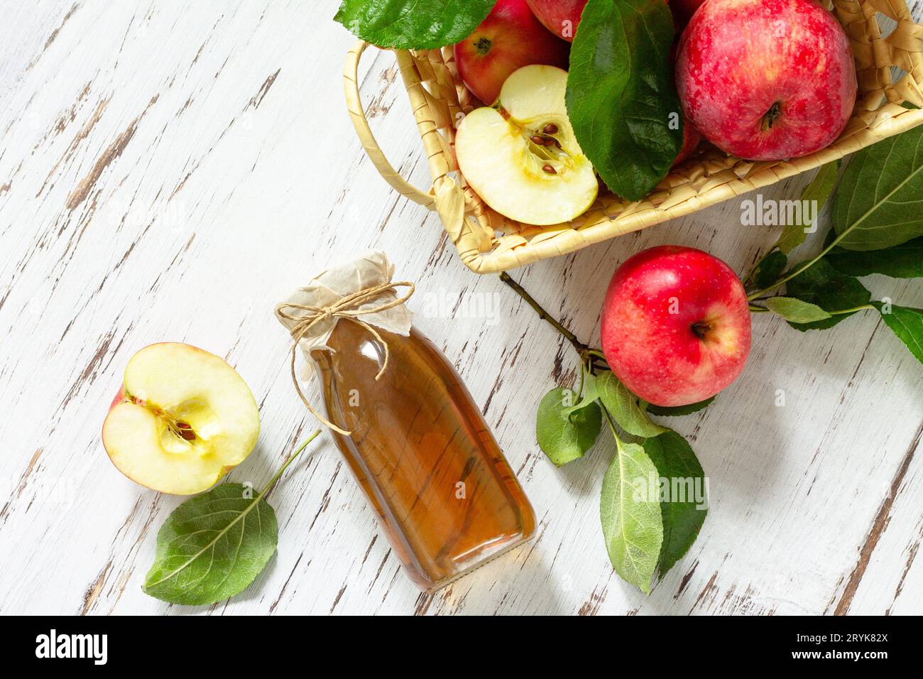 Cibo biologico sano. Aceto di mele, una bottiglia di aceto di sidro di mele su un tavolo rustico. Vista dall'alto sfondo piatto. Foto Stock