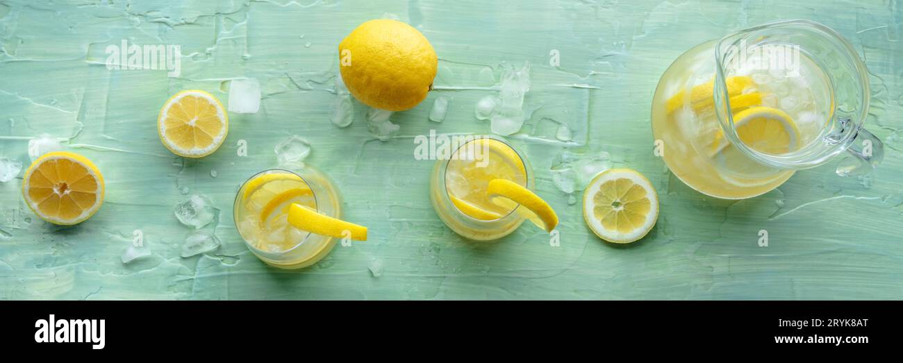 Panorama delle limonate. Acqua al limone con ghiaccio, due bicchieri e una caraffa Foto Stock
