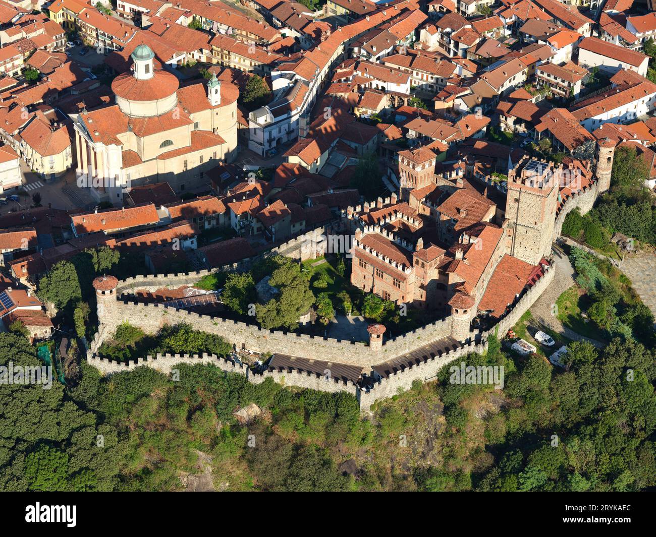 VISTA AEREA. Il Castello Pavone si affaccia sulla Chiesa di Sant'Andrea nel centro storico di Pavone Canavese. Piemonte, Italia. Foto Stock