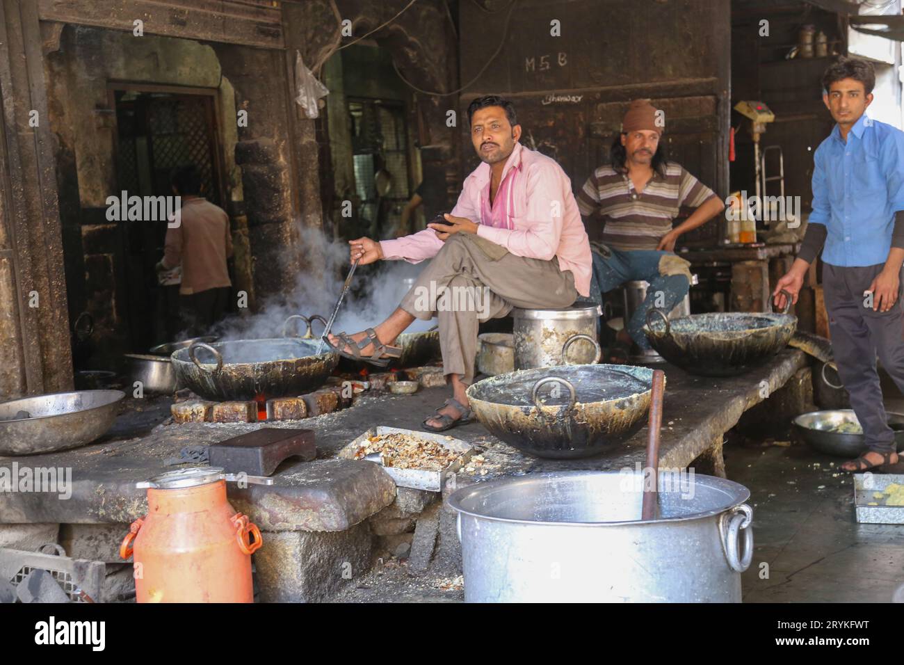 Jodhpur, Rajasthan, India - 11 gennaio 2017: Un uomo indiano che coccola nella cucina a legna, con pentole in un bazar di Street food Foto Stock