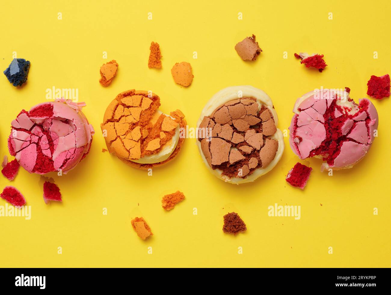 Macaroni rotondi spezzati con briciole su sfondo giallo, dessert delizioso, vista dall'alto Foto Stock