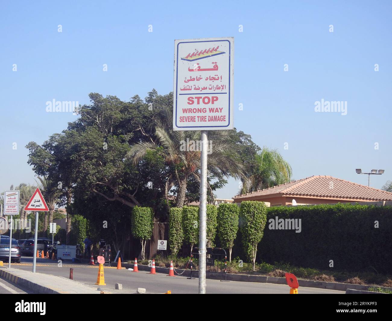 Cairo, Egitto, 17 settembre 2023: Cartello segnaletico stradale, traduzione dell'arabo (Stop, Wrong Way, severe Tire Damage), come precauzione prima di una barriera a picco Foto Stock