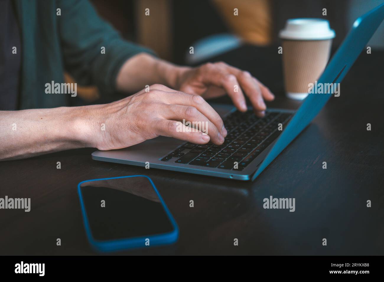 Primo piano delle mani di un uomo che digita un messaggio di testo sulla tastiera del notebook. Configurazione per il lavoro da casa e moderna tecnologia di comunicazione. La ma Foto Stock