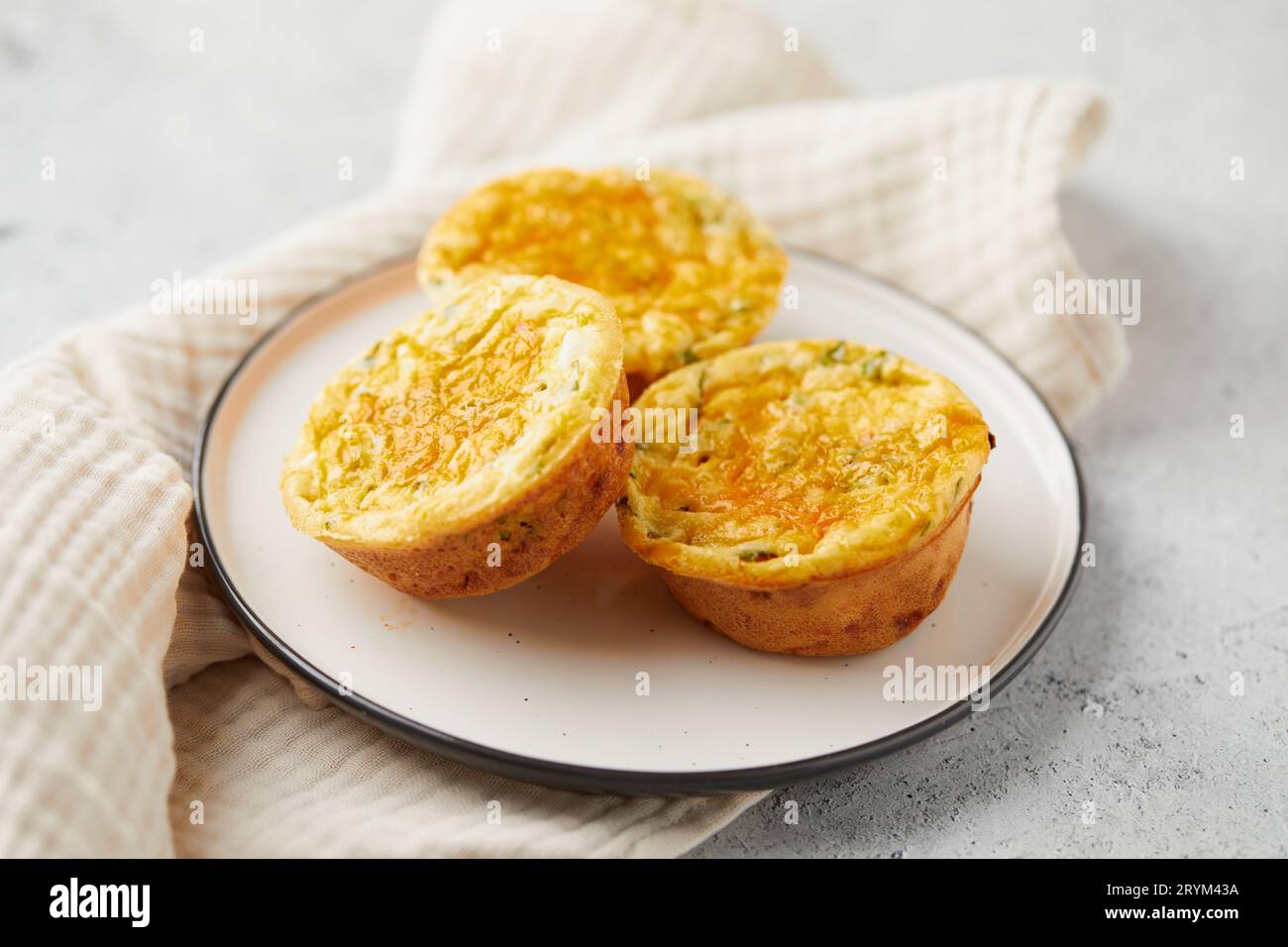 Gustosi muffin con uova, formaggio feta, cheddar e spinaci su sfondo chiaro Foto Stock