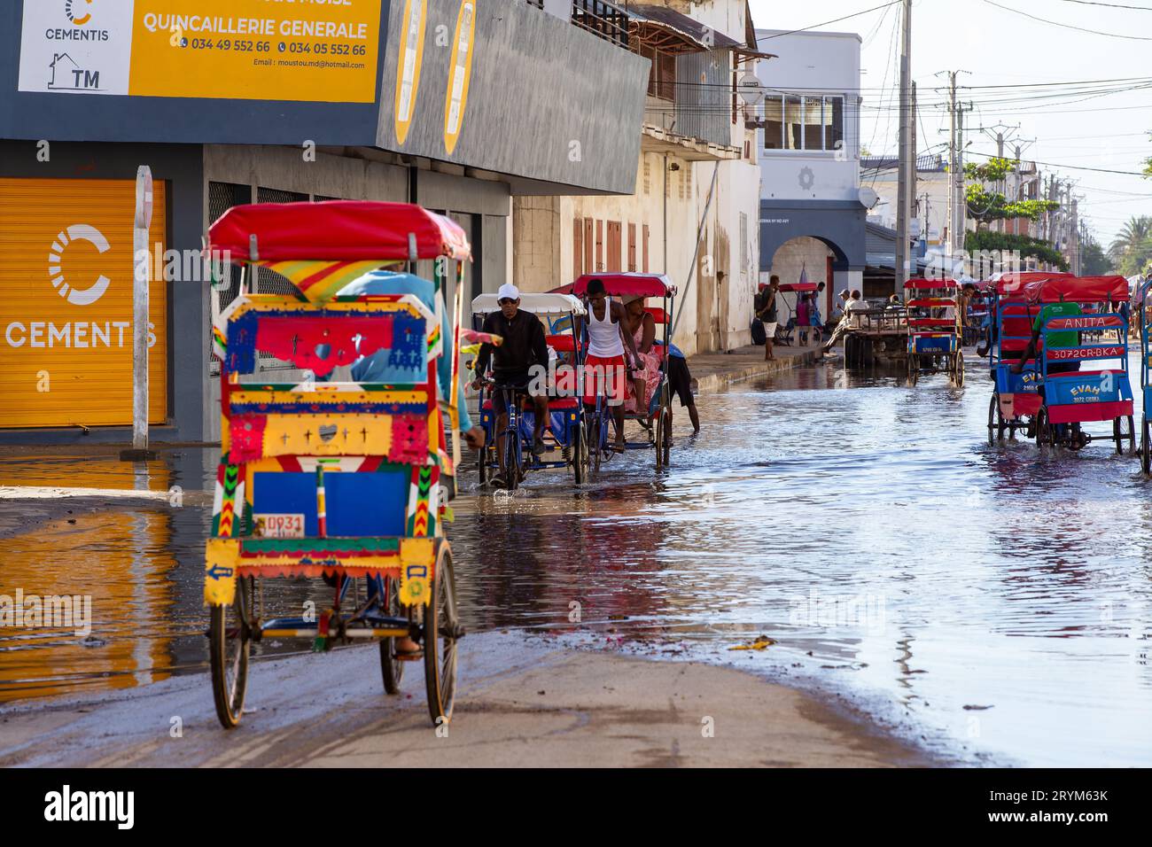 Bicicletta tradizionale risciò con gente malgascia sulla strada di Toliara, uno dei modi per guadagnare soldi. La vita quotidiana sul Foto Stock