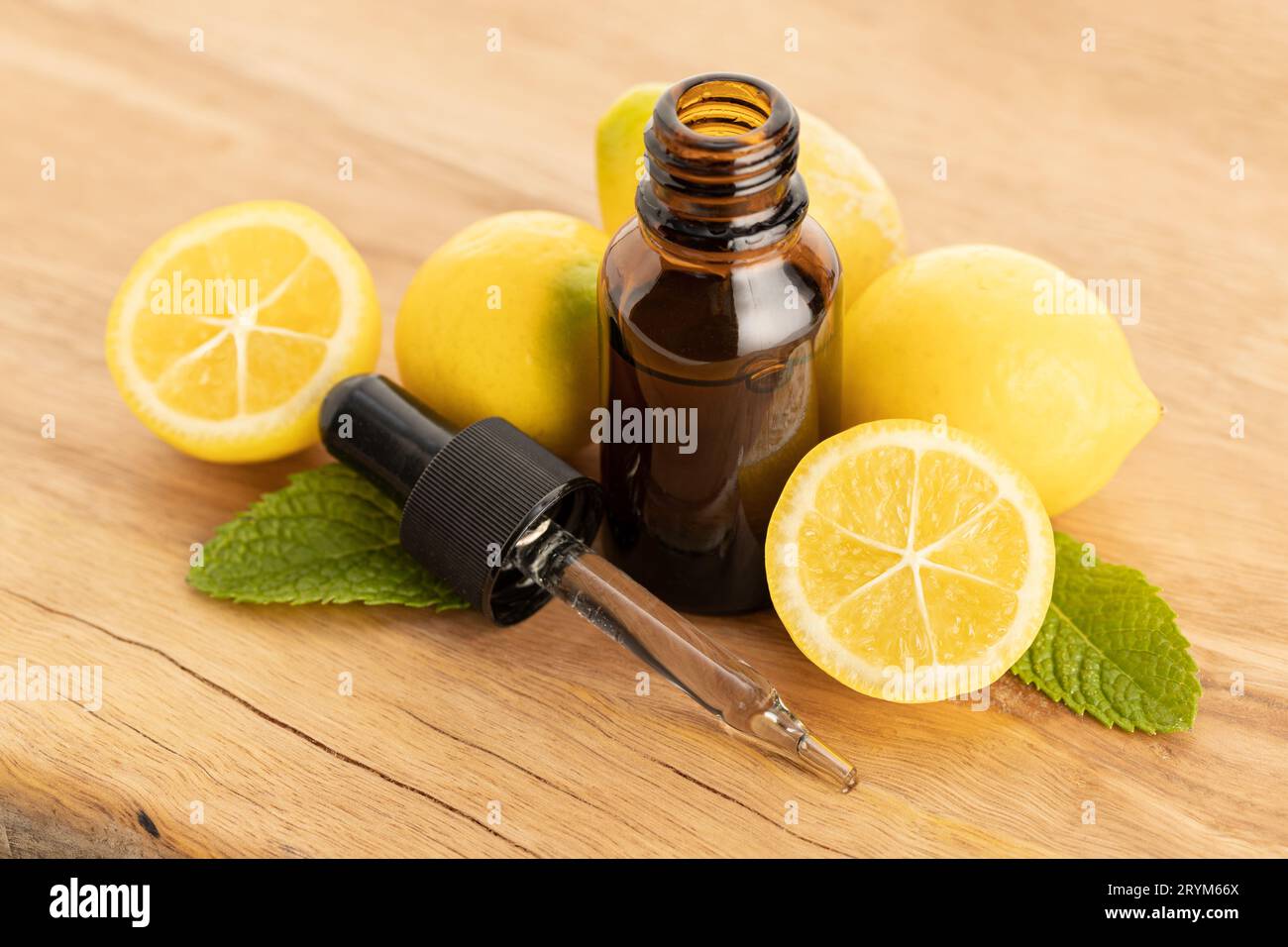 Olio essenziale di limone su tavola di legno Foto Stock