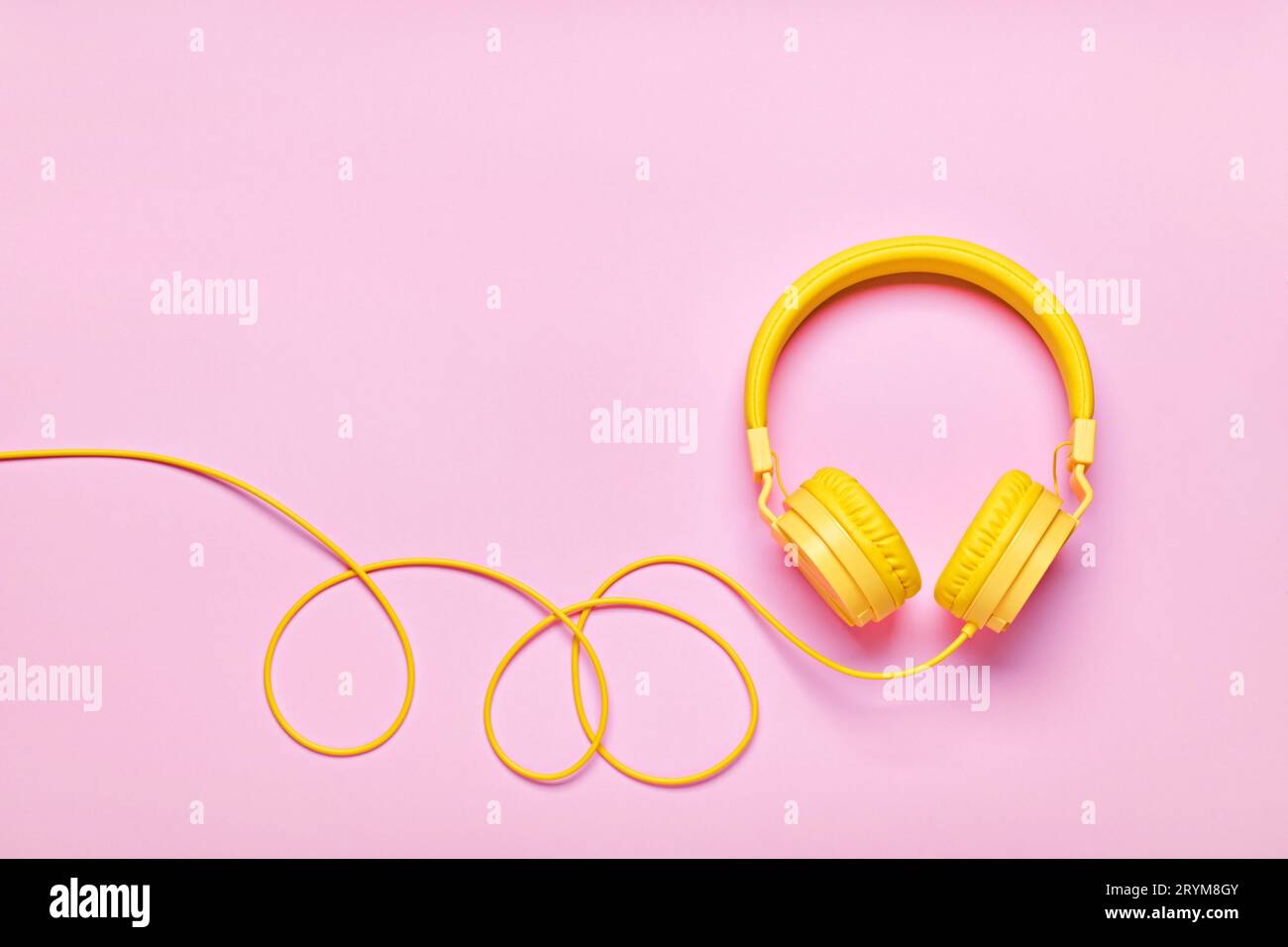 Cuffie gialle su sfondo rosa. Minimal Music Concept, piatto, spazio per le copie Foto Stock