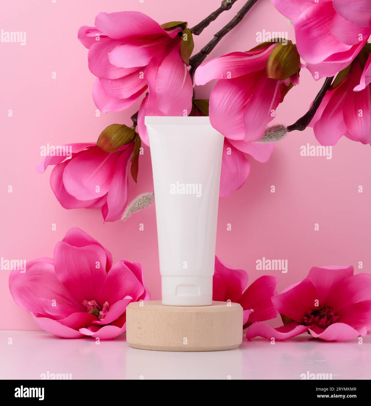 Tubo di plastica bianco per cosmetici liquidi su sfondo rosa, confezione Foto Stock