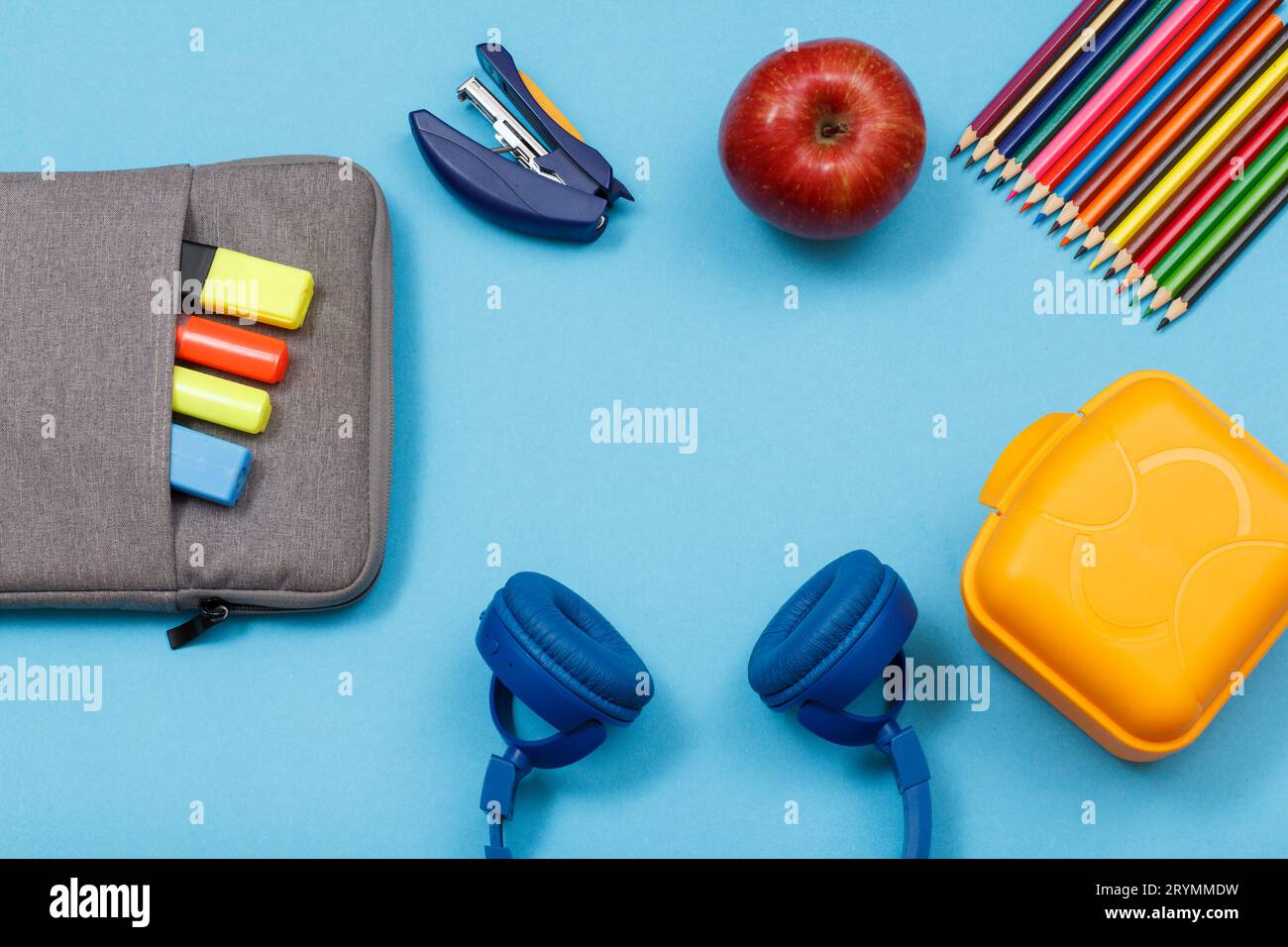 Pranzo al sacco, matite colorate, una mela, cuffie, astuccio per mela e matita con pennarelli colorati Foto Stock