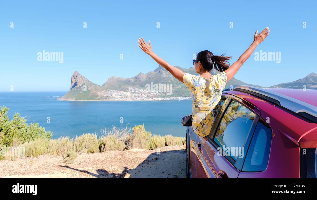 Donna fuori dal finestrino di un'auto con le mani in alto, un'auto al Chapmans Peak Drive a città del Capo in Sudafrica Foto Stock