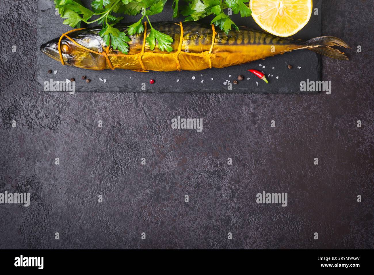 Pesce di sgombro affumicato su fondo di pietra nera Foto Stock