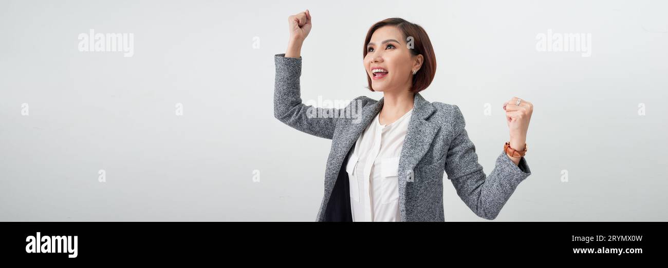 Donna di successo con le braccia alzate che festeggia su uno striscione bianco Foto Stock