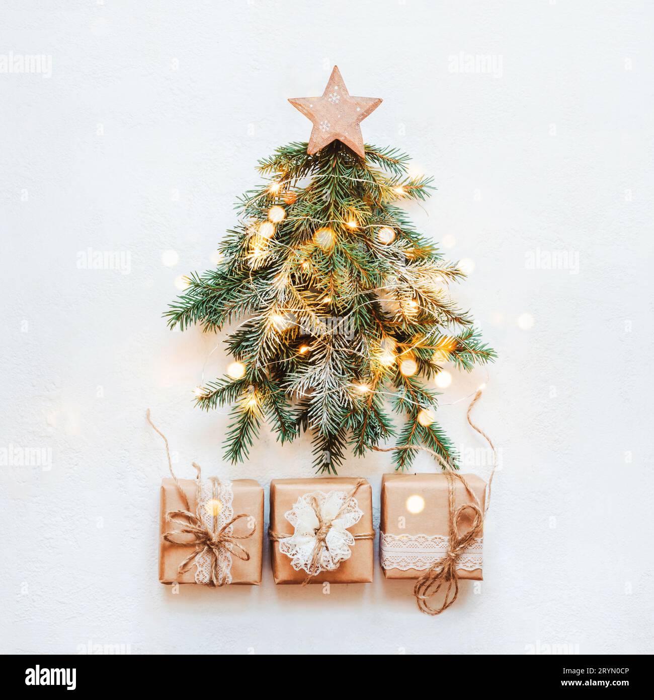 Concetto di Natale zero rifiuti. Albero di Natale realizzato con rami di abete naturale con stella di legno e pizzo di carta regalo Foto Stock