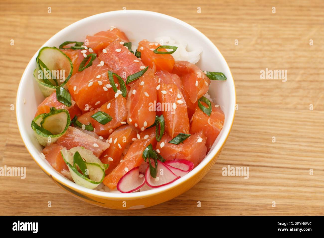 Pollo hawaiano con salmone e semi di sesamo, riso bollito, cetriolo fresco, ravanello e cipolle verdi Foto Stock