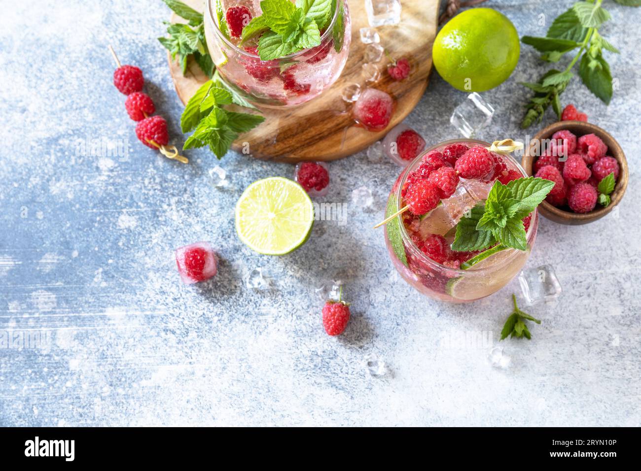 Cocktail sseltzer duro con lamponi e lime su un tavolo in pietra grigia. Vista dall'alto sfondo piatto. Spazio di copia. Foto Stock