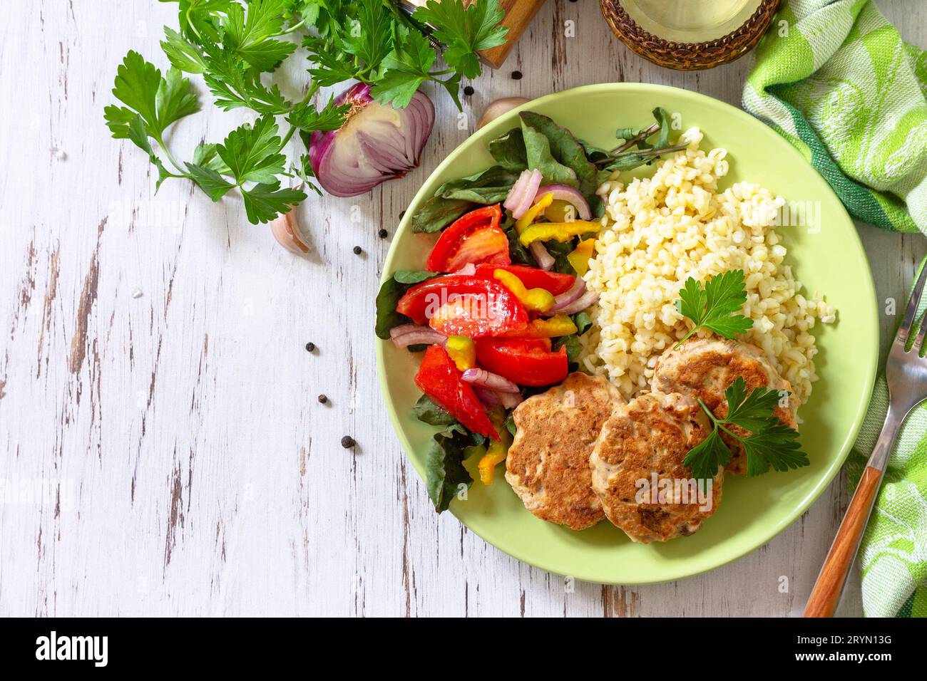 Cibi vegani sani, diete keto o paleo. Cotolette di pesce rosso fatte in casa con bulgur e insalata di verdure fresche su un tavolo di legno. In alto Foto Stock